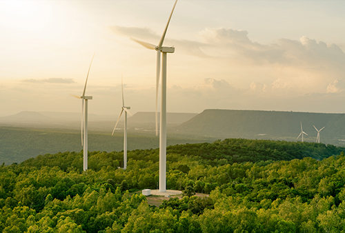 Windmills on a prairie with mountains behind